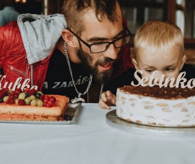 A joyful birthday scene with a father and child. Cakes adorned with decorations and age markers.