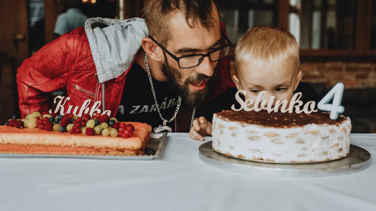 A joyful birthday scene with a father and child. Cakes adorned with decorations and age markers.